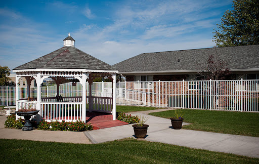 A serene outdoor space featuring a white gazebo surrounded by well-maintained lawns and pathways.