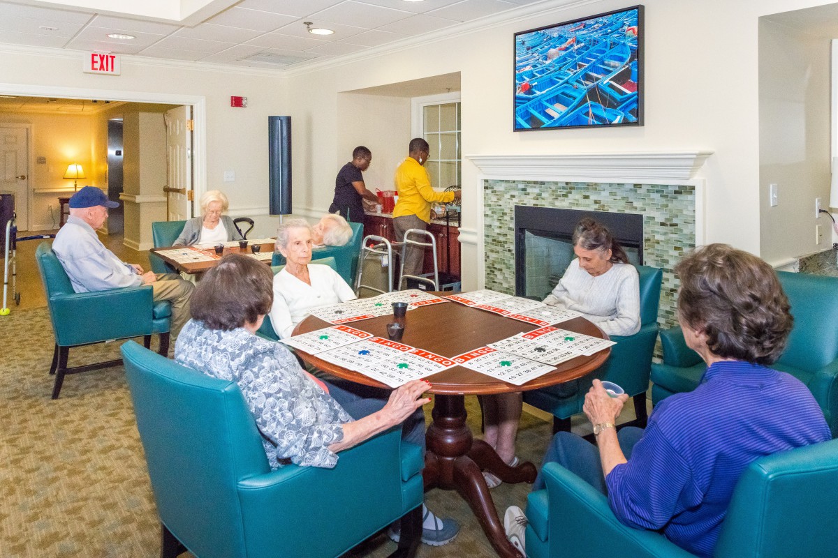 A group of elderly individuals engaged in a social activity at a nursing home.
