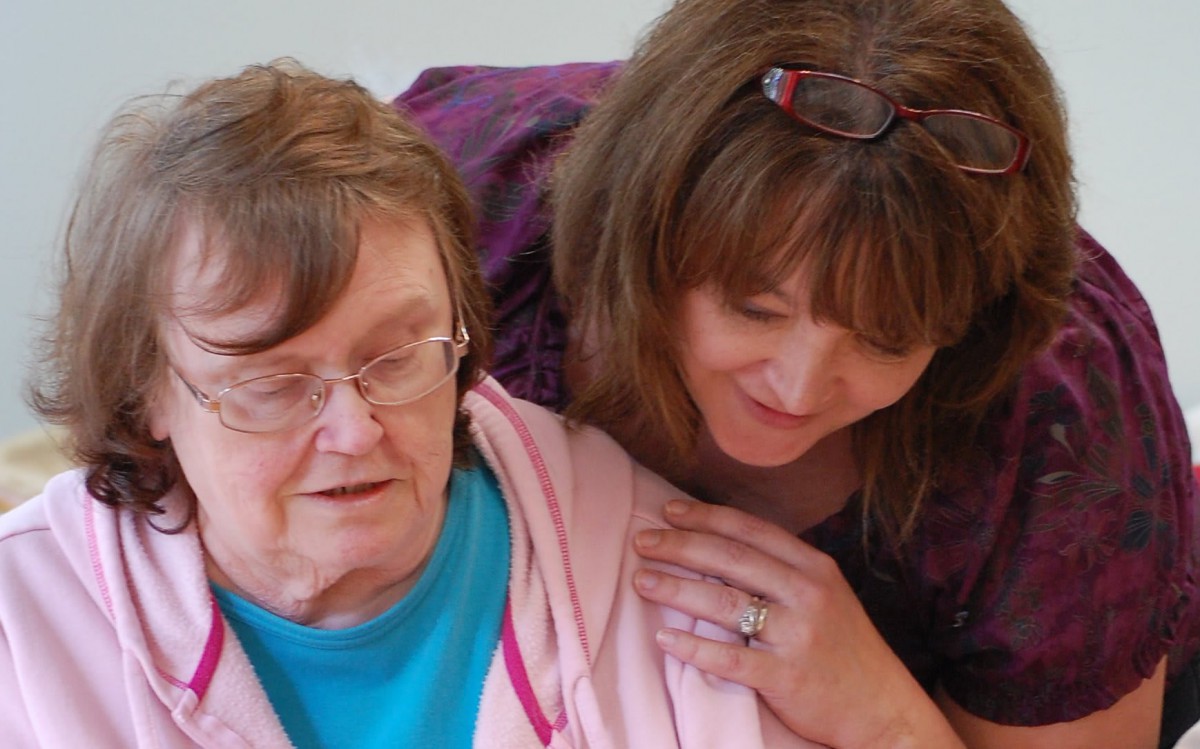 An elderly woman receiving care and support from a loved one.