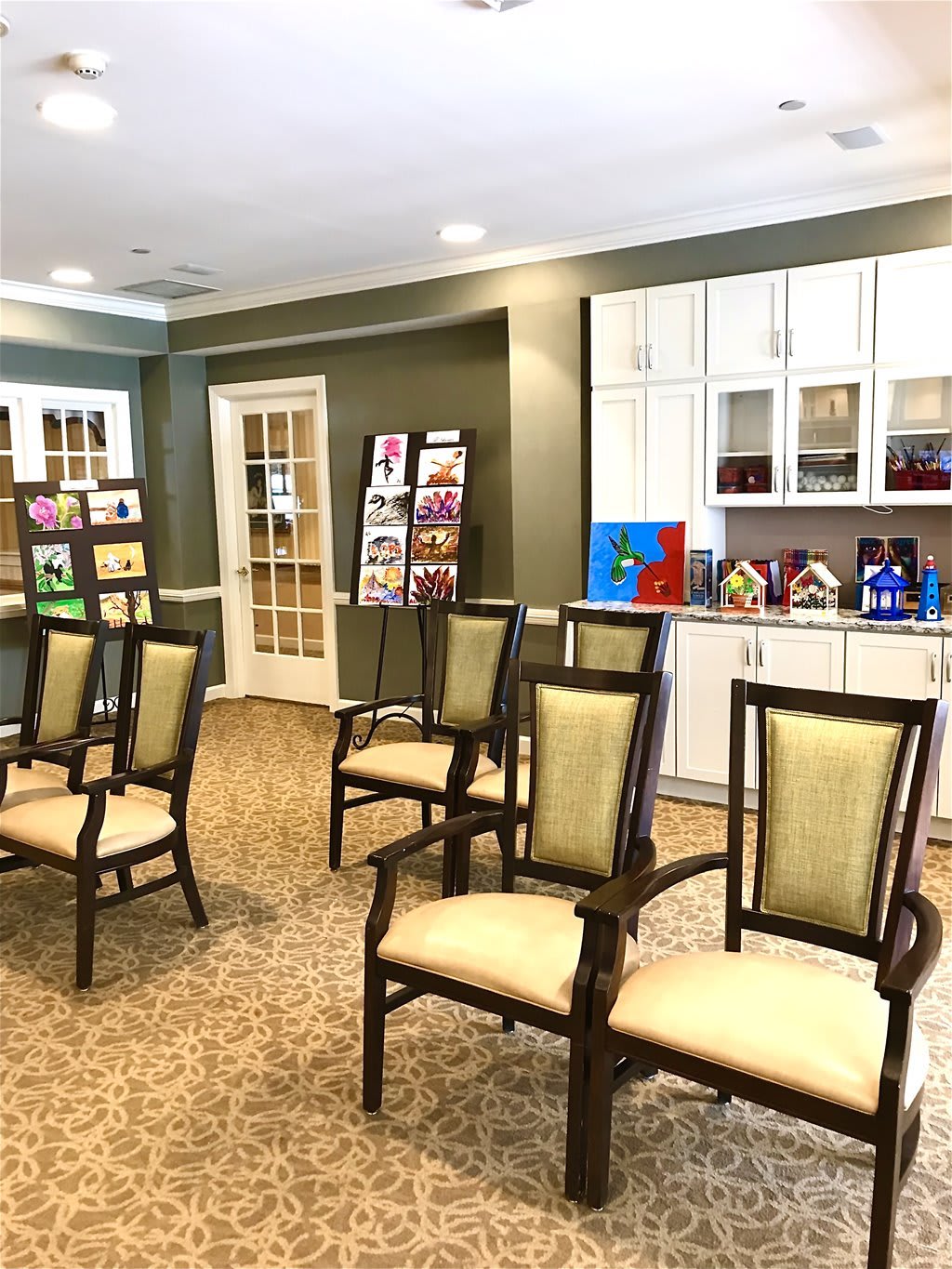 A well-lit waiting room with chairs and an art display on the walls.