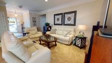 A cozy living room with cream sofas, a wooden coffee table, and decorative wall art.