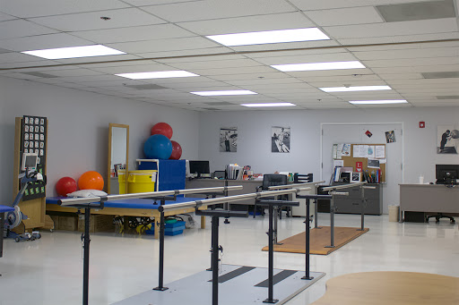 A well-equipped physical therapy room featuring exercise equipment and therapy bars.