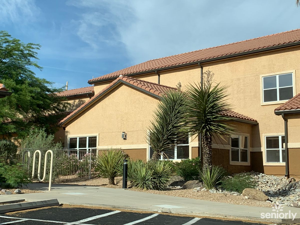 A residential building with desert landscaping and clear skies.