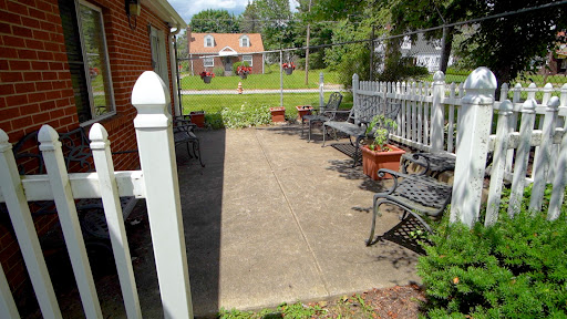 A serene outdoor patio space featuring metal seating and potted plants, ideal for relaxation.
