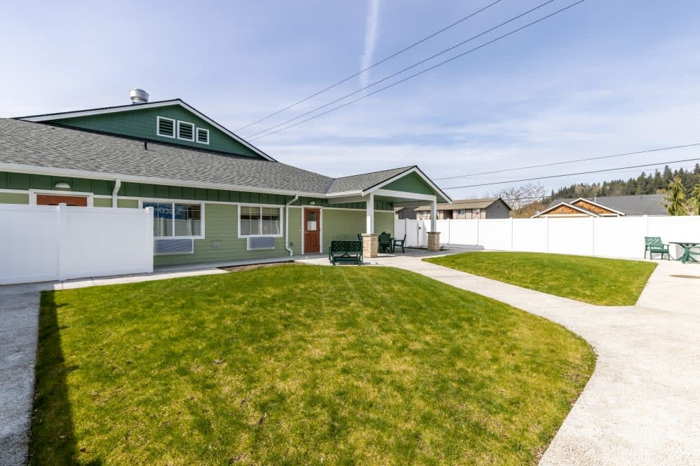 A suburban house with a well-maintained lawn and a fenced yard.