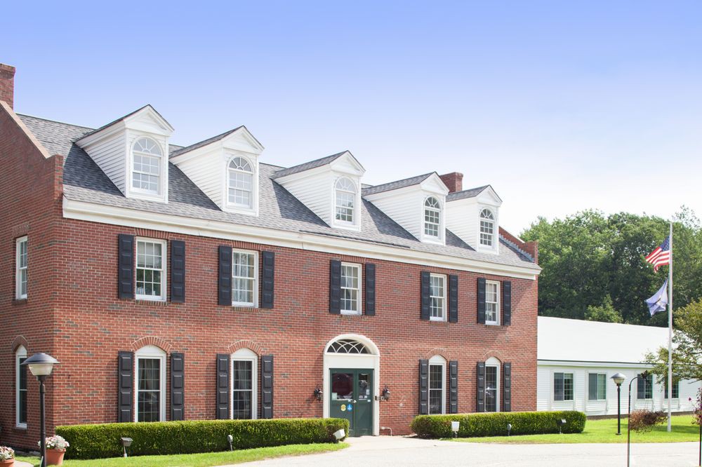 A large colonial-style brick house with multiple windows and dormers.