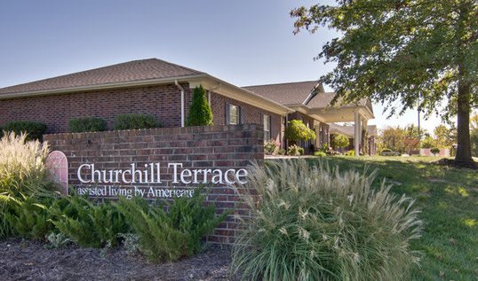 Entrance to Churchill Terrace with landscaped surroundings and a brick sign.