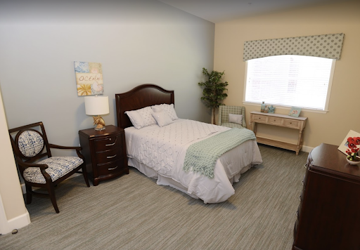 A cozy and modern bedroom featuring a single bed, nightstand, and a workspace by the window.
