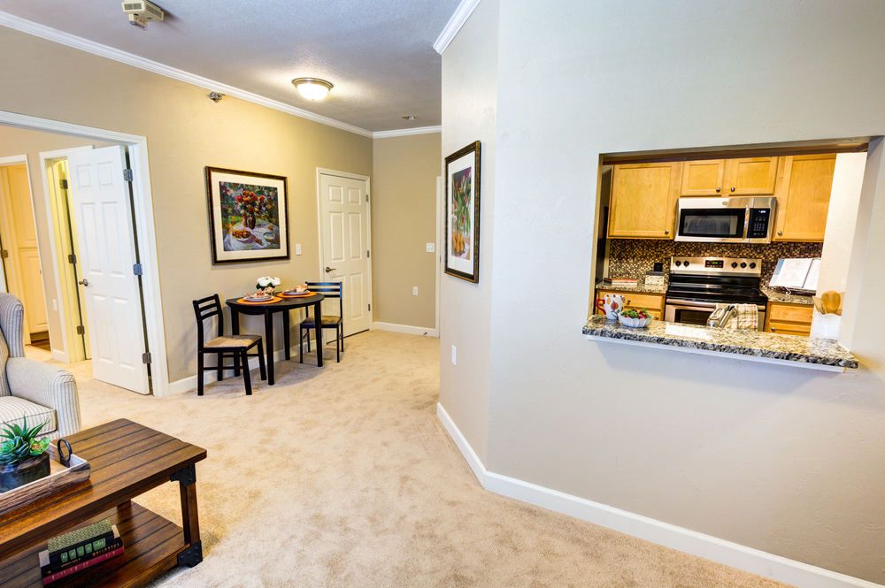 A cozy apartment interior featuring a small dining area and a view into the kitchen.
