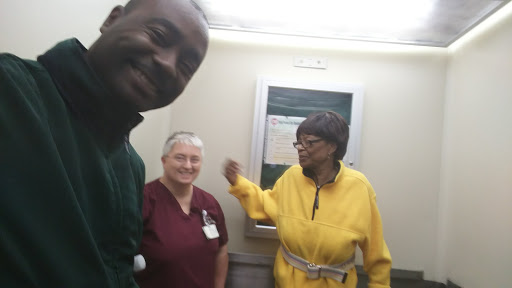 A joyful moment captured inside a hospital elevator with staff and a patient.