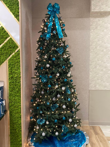 A beautifully decorated Christmas tree adorned with blue ribbon and ornaments.