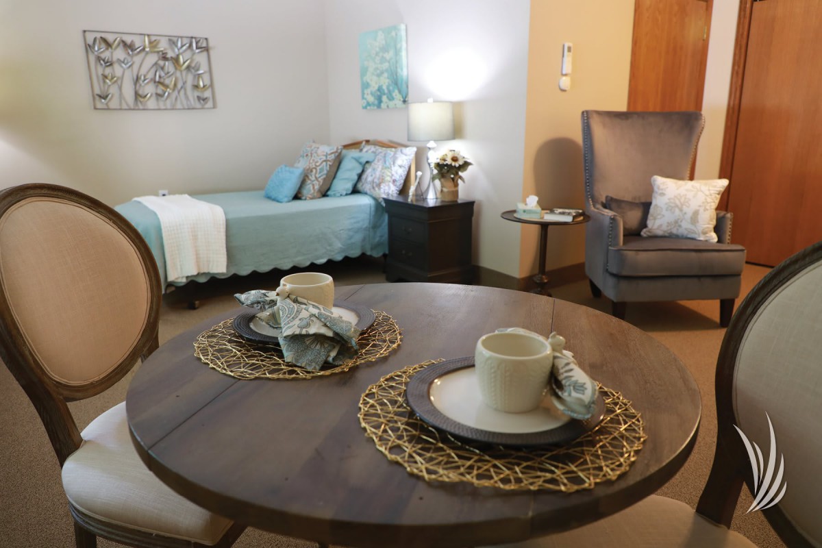 A cozy living space featuring a dining area and a bed in a modern interior design.