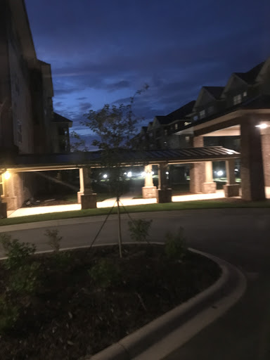 A well-lit parking area beside a building, captured during twilight.