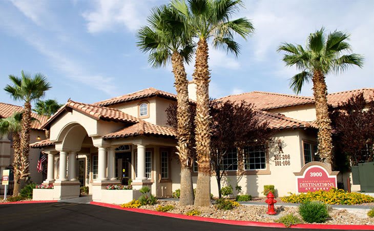A beautiful suburban house surrounded by palm trees and well-maintained landscaping.