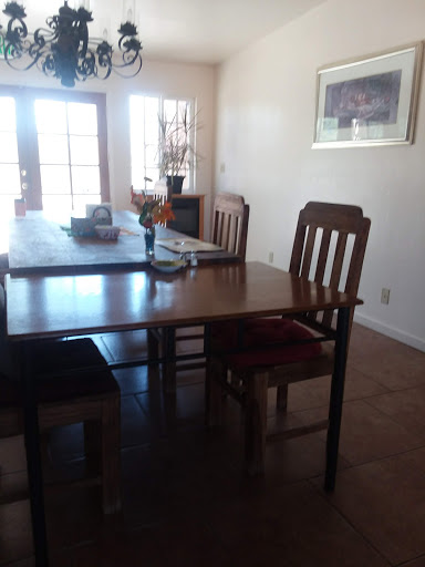 A cozy dining area featuring a wooden table and chairs, illuminated by natural light.