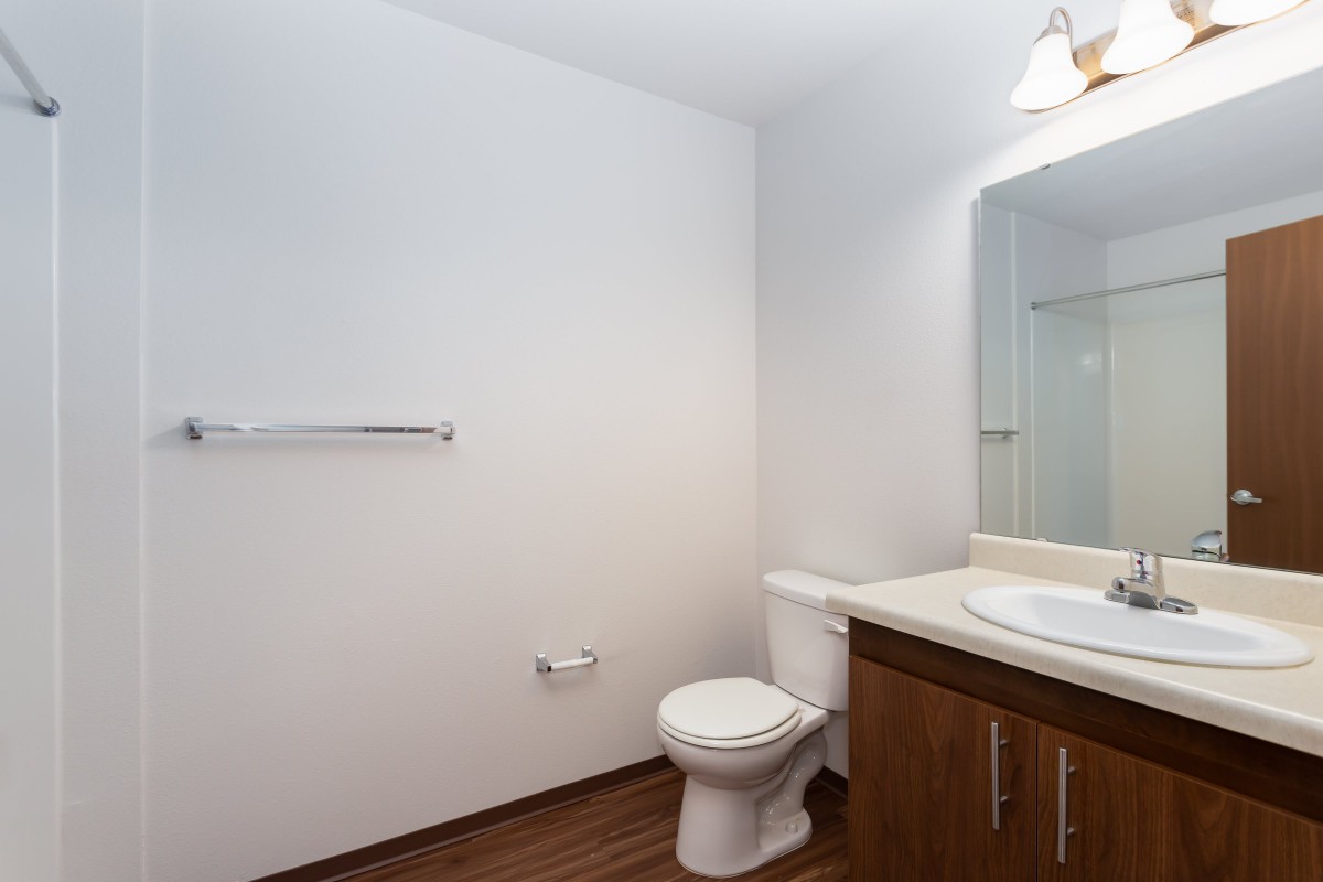 A minimalist bathroom with a toilet, sink, and mirror.