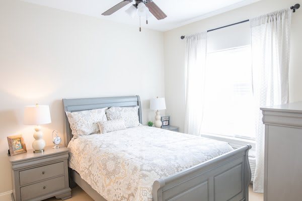 A cozy bedroom with neutral tones and ample natural light.