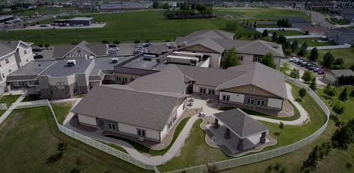 Aerial view of a modern community building surrounded by green landscapes.