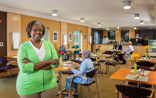 A joyful moment in a senior community center, highlighting the warm interaction between caregivers and residents.