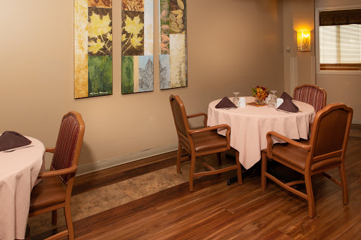 A cozy restaurant dining area featuring a neatly set table and elegant wall decor.