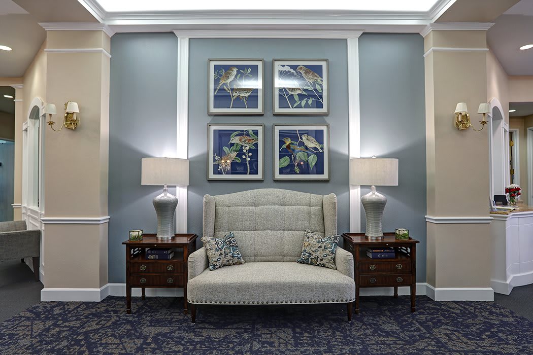 A stylish living room with a central sofa, elegant artwork, and matching lamps.