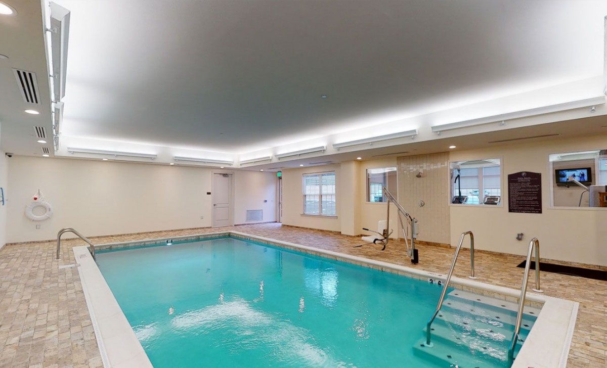 An indoor swimming pool with clean, clear water and bright lighting.