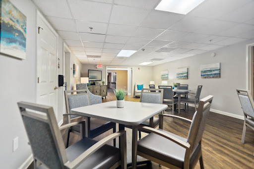 A spacious and modern common area featuring tables and chairs, designed for social gatherings.