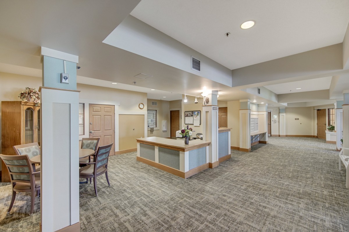 A spacious and well-lit reception area with a central counter and seating.