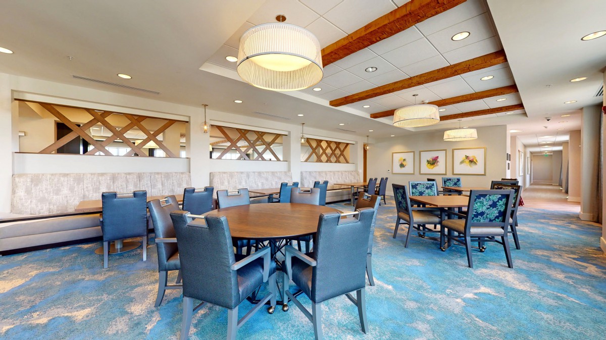 A spacious dining area with modern furnishings and elegant lighting.