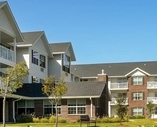 A residential apartment building with modern architecture under a clear blue sky.