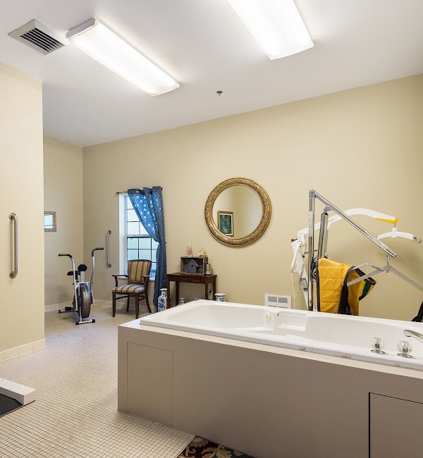 A well-lit bathroom interior featuring a bathtub and exercise equipment.