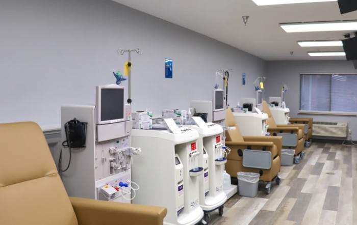 A row of dialysis machines and chairs in a healthcare facility.