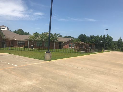A sunny day at a community facility featuring a basketball court and green space.
