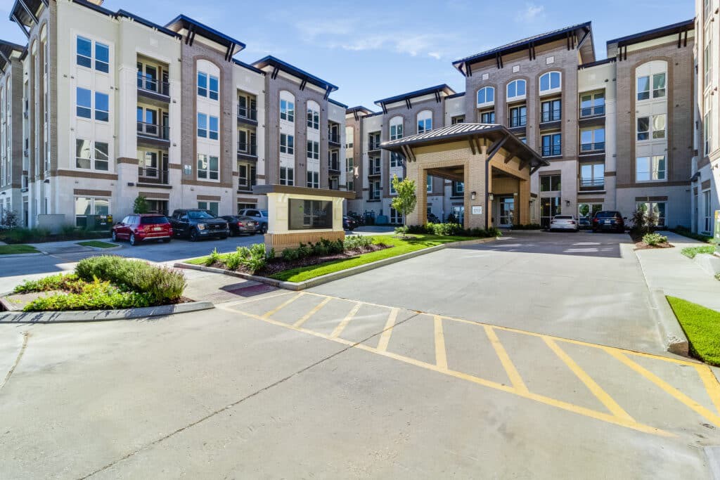 Exterior view of a modern hotel with a parking lot.