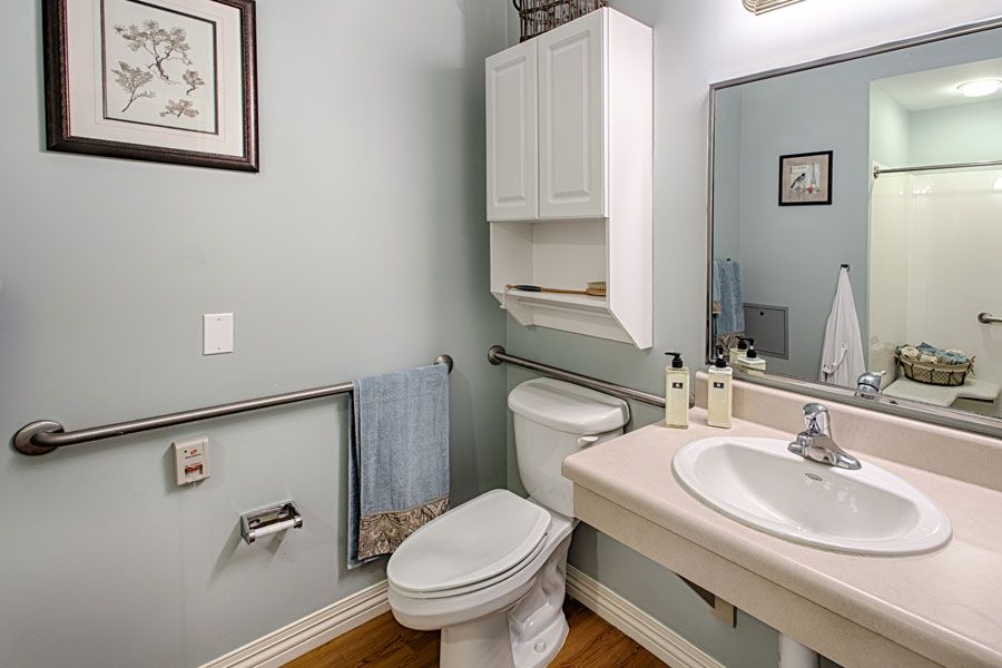 A small, minimalist bathroom with a toilet, sink, and mirror.
