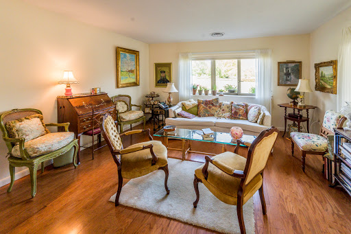 A cozy and elegant living room featuring comfortable seating, warm wooden floors, and bright natural light.