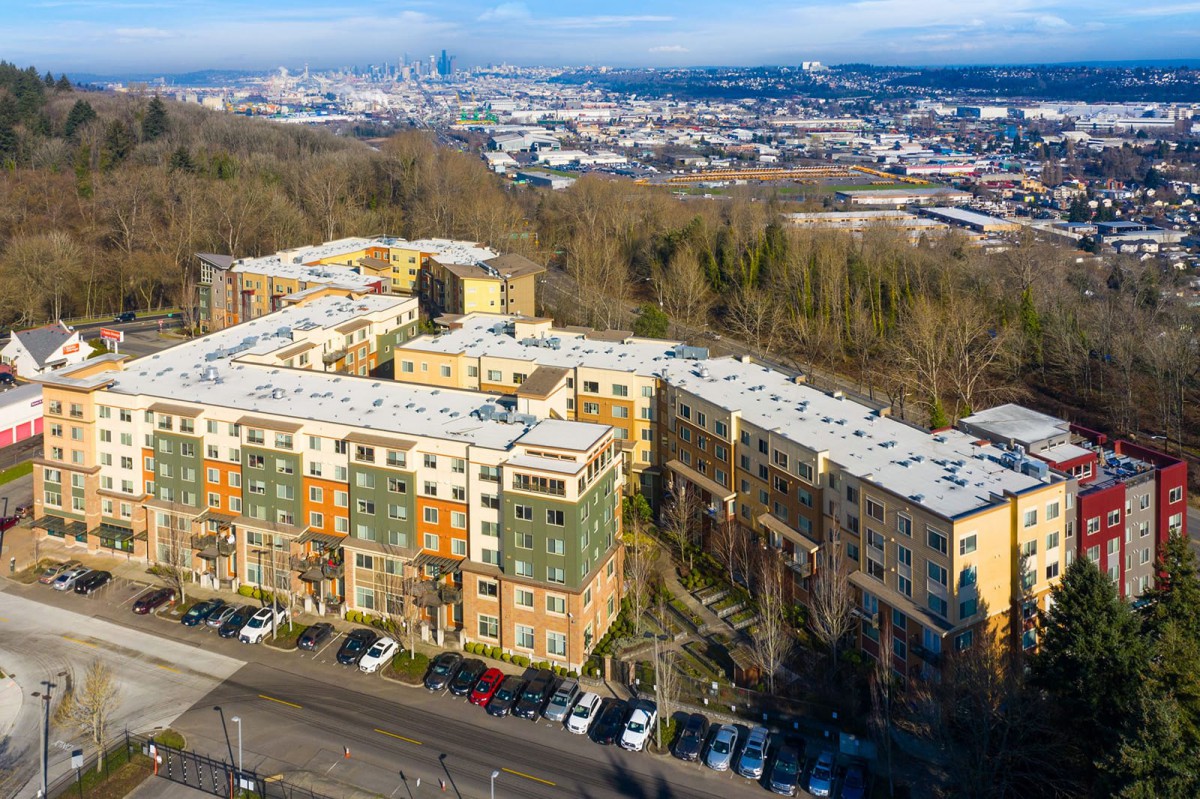 Aerial view of colorful apartment buildings with a cityscape backdrop in winter.