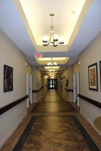 A well-lit interior hallway featuring decorative artwork and doors on either side.