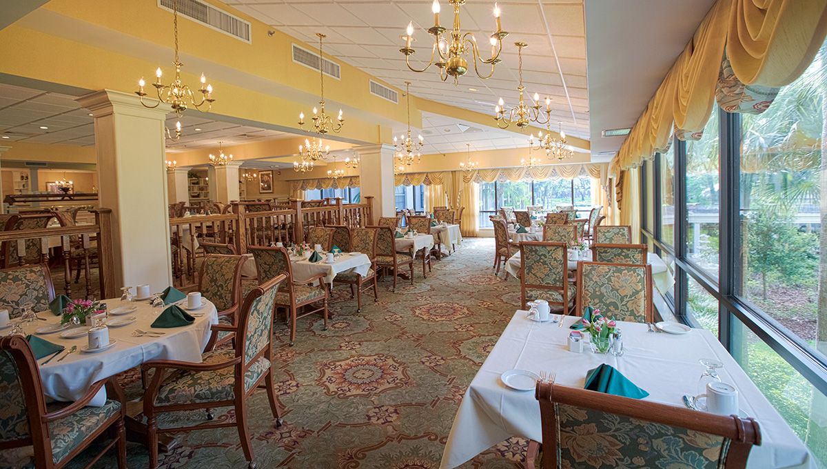 An elegant dining area featuring chandeliers and well-arranged tables.