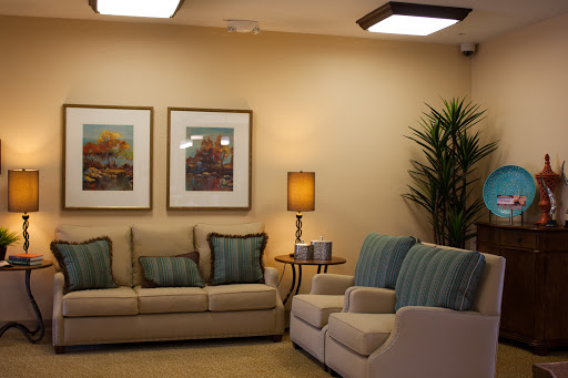 A cozy living room featuring comfortable sofas, decorative artwork, and a stylish lamp.