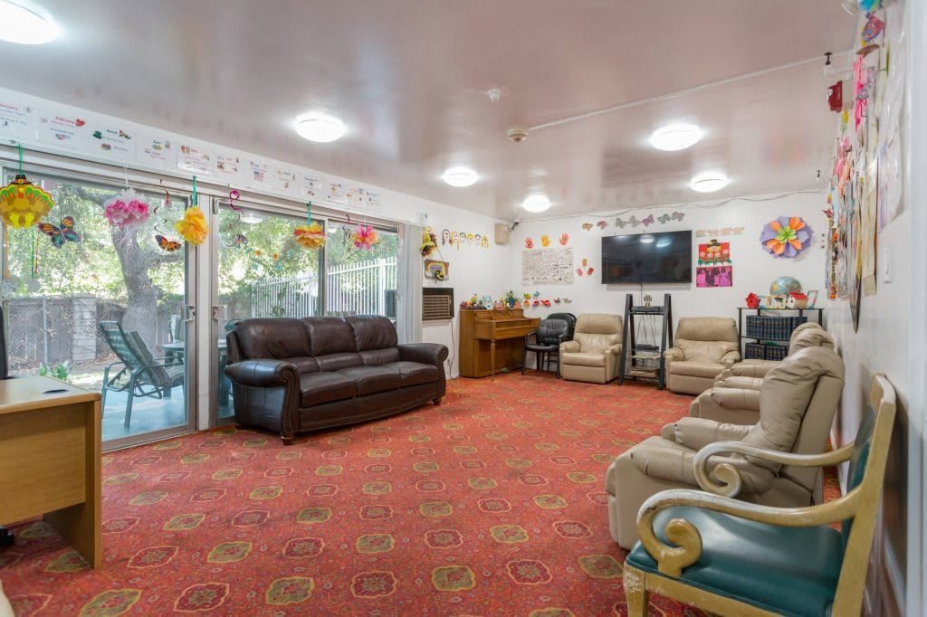 A cozy living room with multiple sofas, a television, and festive decorations.