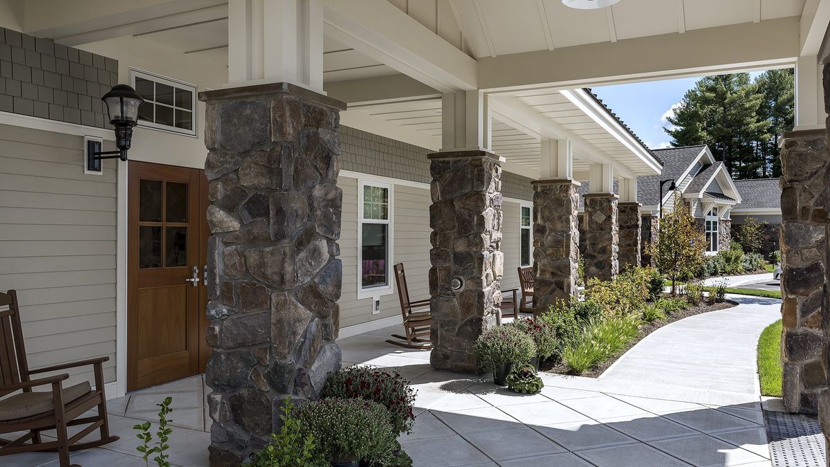 A building entrance with stone columns and landscaped surroundings.