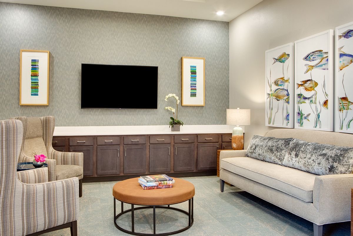 A contemporary living room featuring a sleek design with a sofa, television, and stylish decor.