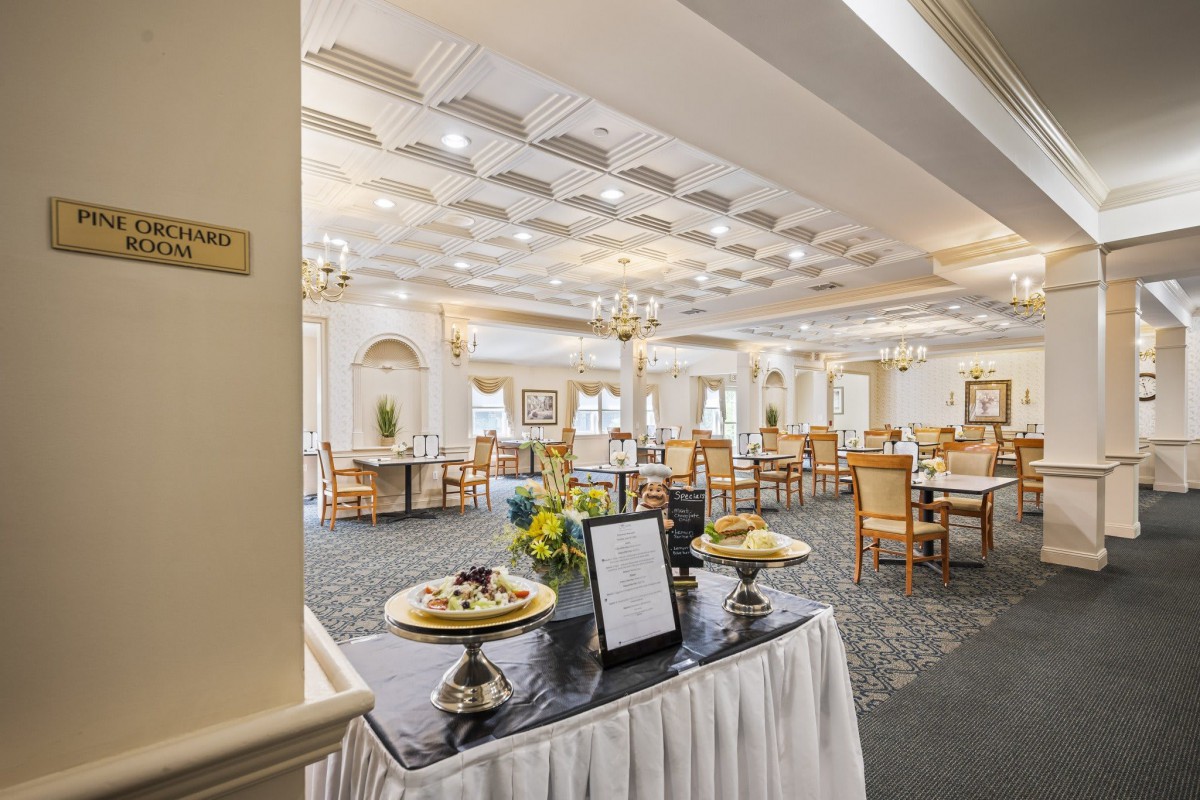 An elegant dining room with neatly arranged tables and chairs, featuring stylish decor and lighting.