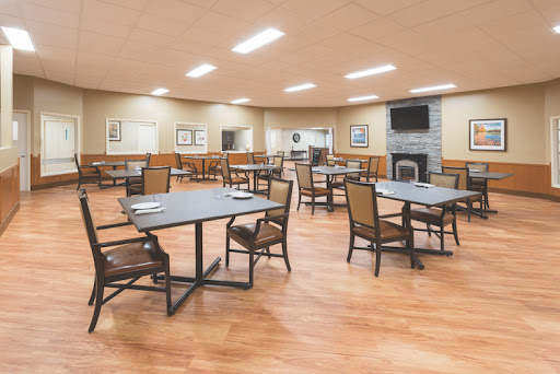 A spacious and well-lit dining area featuring multiple tables and chairs.