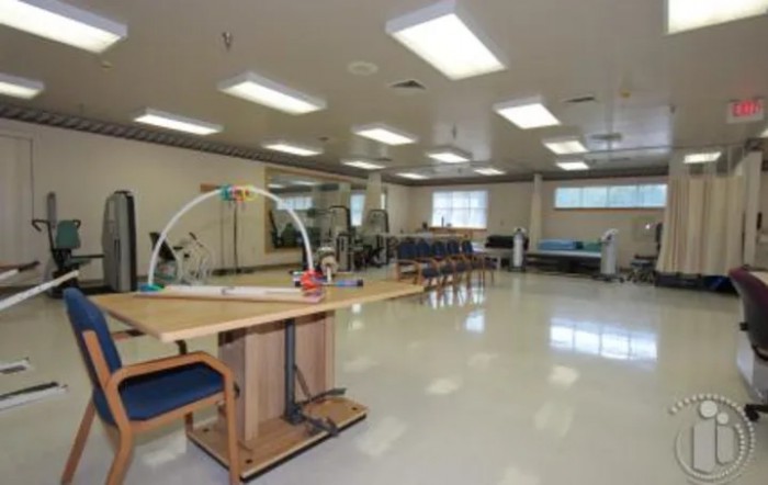 A spacious physical therapy room equipped with various exercise equipment.