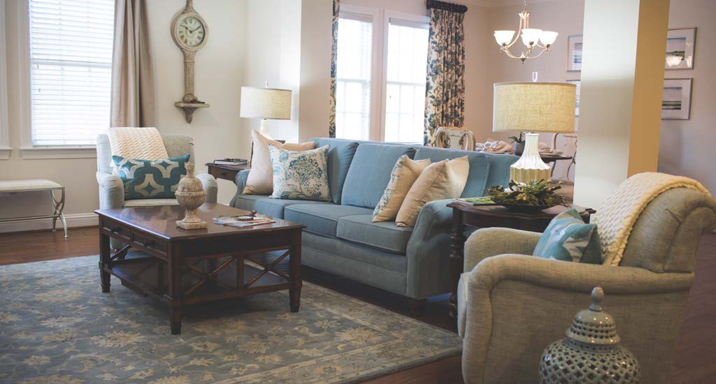 A cozy living room with a blue sofa, elegant armchairs, and stylish decor.