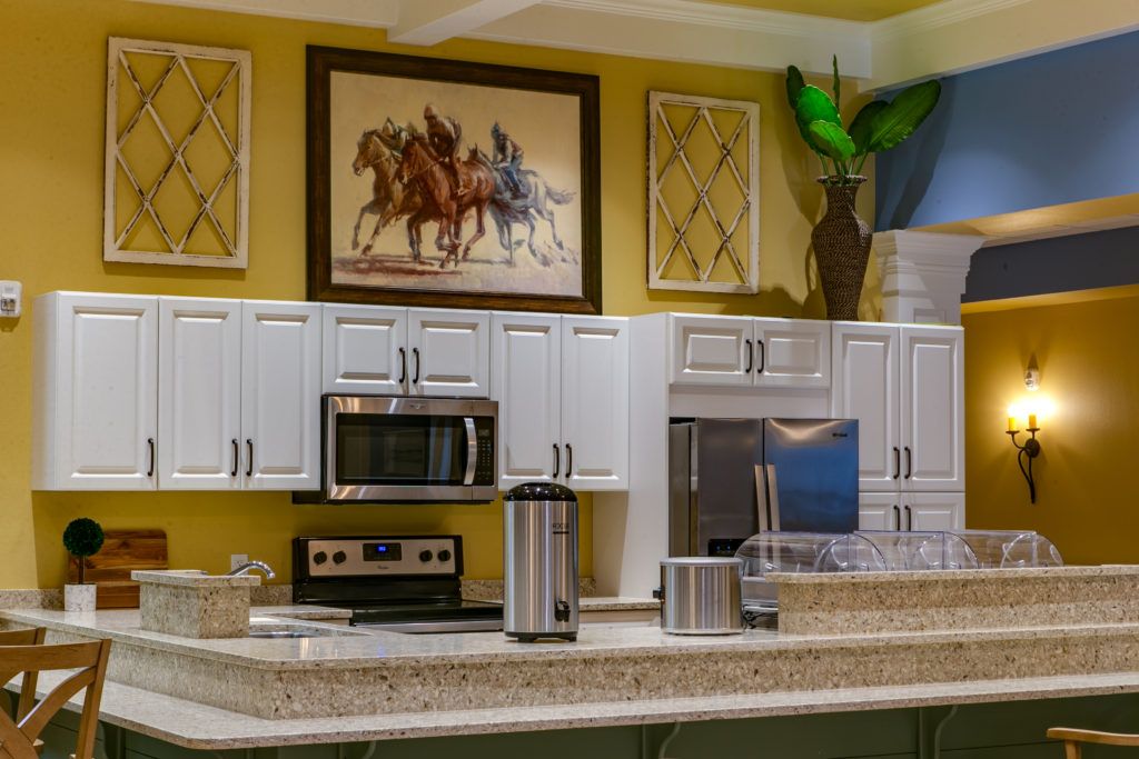 A modern kitchen with stainless steel appliances, artwork above the cabinets, and sleek decor.