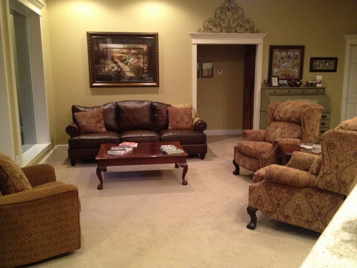 A cozy, traditionally decorated living room with a sofa, armchairs, and a coffee table.