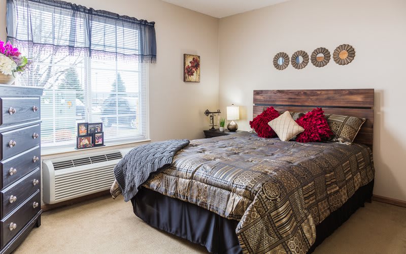Cozy and well-decorated bedroom with a large bed, pillows, a window, and stylish decor.